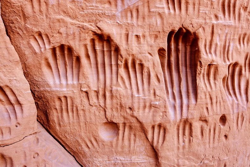 The Indian Cave in Kodachrome Basin State Park has over a hundred grooves or handprints carved into the sandstone wall outside a shallow overhang. It's not certain that they were made by American Indians.