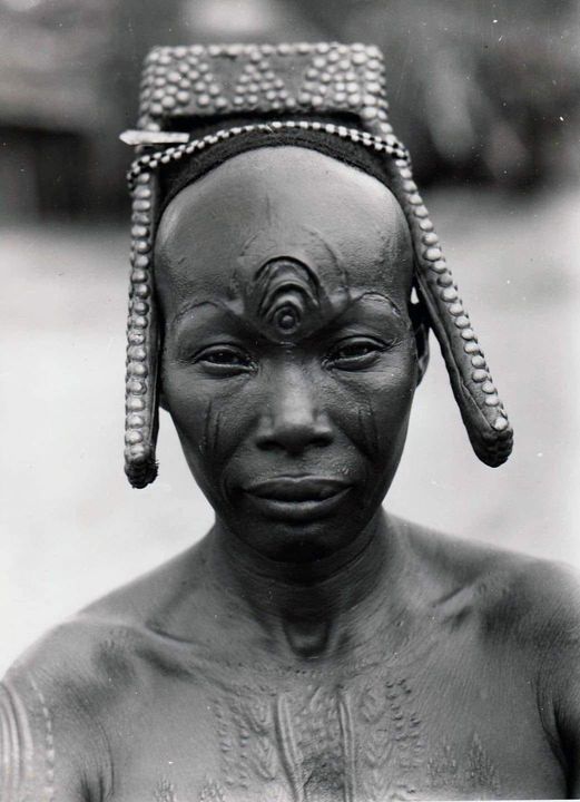A shaman woman of the Mongo people of the Democratic Republic of the Congo proudly shows her "3rd eye". Circa 1937.